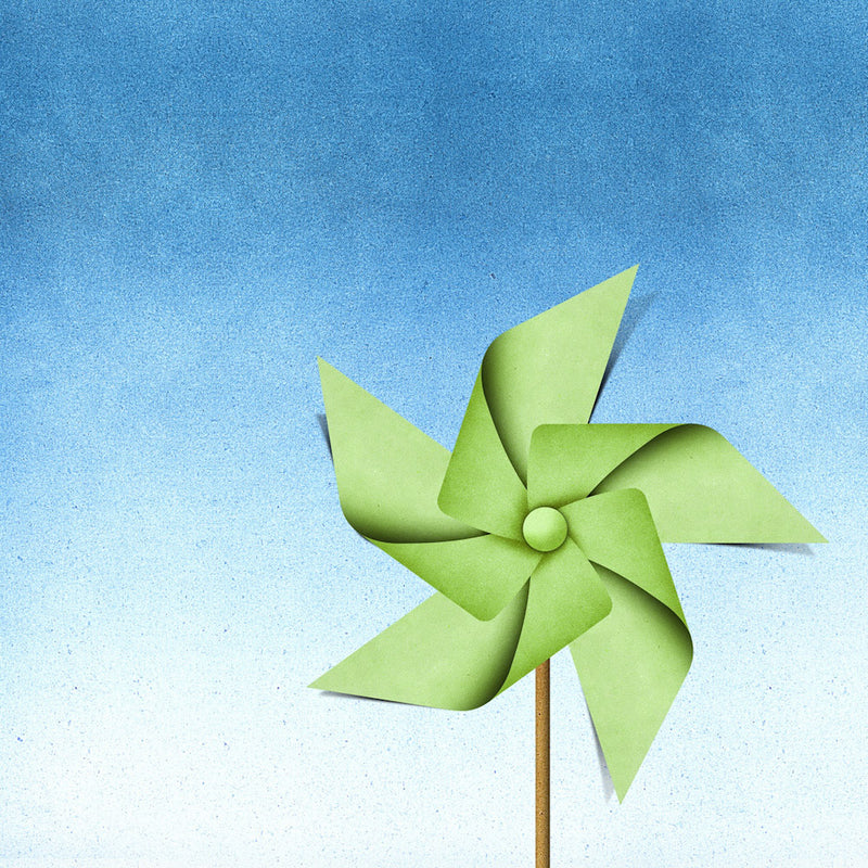 Green paper pinwheel on a blue gradient background.