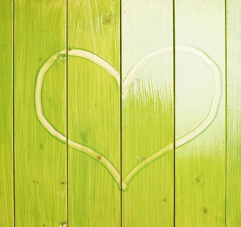 Heart shape drawn on a green wooden background