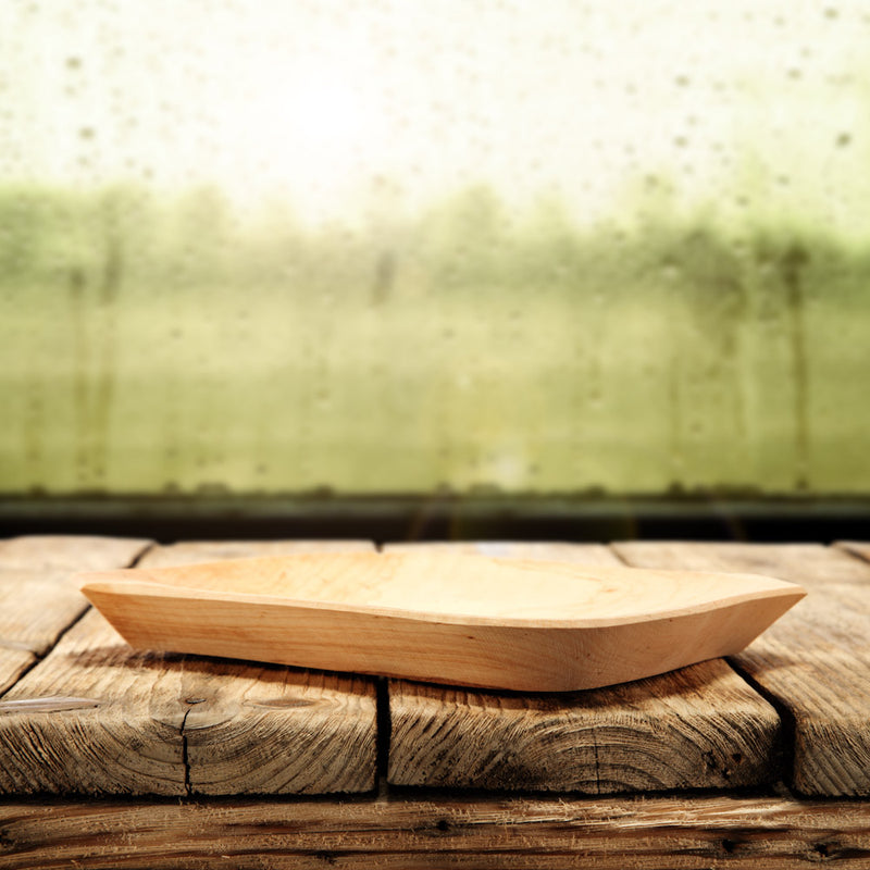 Wooden plate on a rustic wooden surface with a blurred natural background