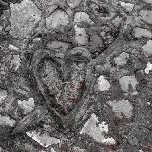 Heart-shaped object embedded in stone with red residue